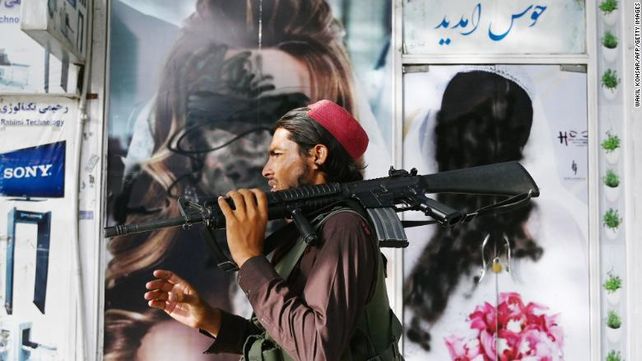 Un talibán en Kabul pasa frente a un salón de belleza cerrado