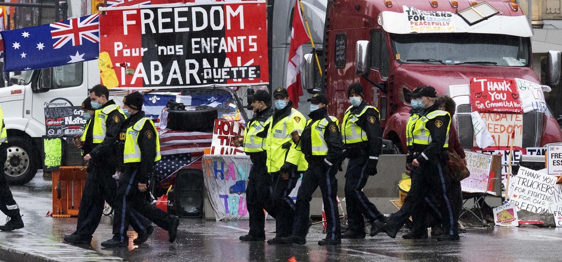 Oficiales de la Policía Provincial de Ontario caminan frente a la protesta de bloqueo de camioneros en curso en Ottawa, el jueves 17 de febrero de 2022. Cientos de camioneros que obstruyen las calles de la capital de Canadá en una protesta contra las restricciones de COVID-19.