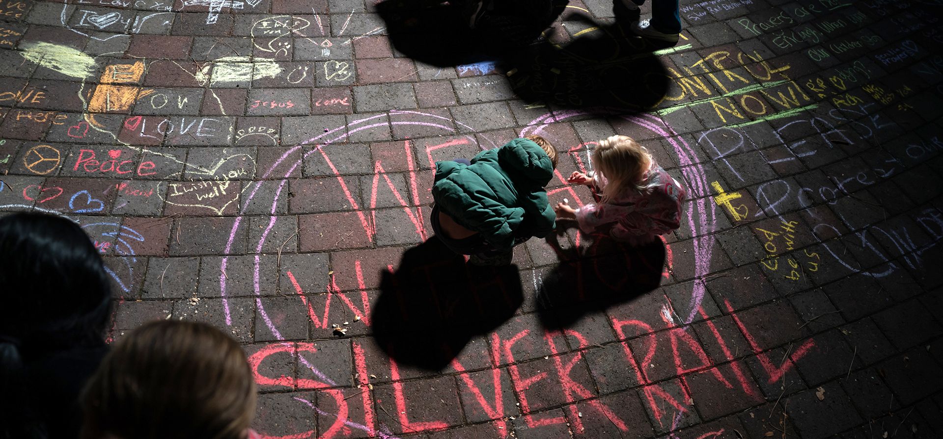 Niños dibujan con tiza durante una vigilia con velas en Drake Park tras el tiroteo mortal en la escuela primaria Silver Rail en Bend, Oregón, el jueves 15 de octubre de 2026. (Eli Imadali/Oregon Public Broadcasting vía AP) Niños dibujan con tiza durante una vigilia con velas en Drake Park tras el tiroteo mortal en la escuela primaria Silver Rail en Bend, Oregón, el jueves 15 de octubre de 2026. (Eli Imadali/Oregon Public Broadcasting vía AP)
