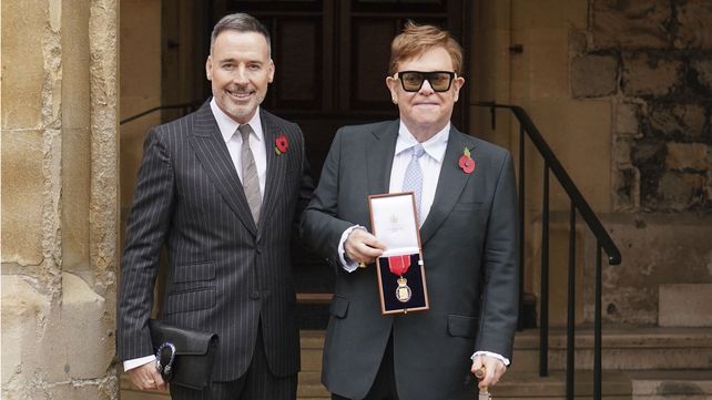 Sir Elton John con su socio David Furnish, luego de ser nombrado miembro de la Orden de los Compañeros de Honor por servicios a la música y a la caridad durante una ceremonia de investidura en el Castillo de Windsor, en Windsor, Inglaterra, el miércoles 10 de noviembre de 2021. 