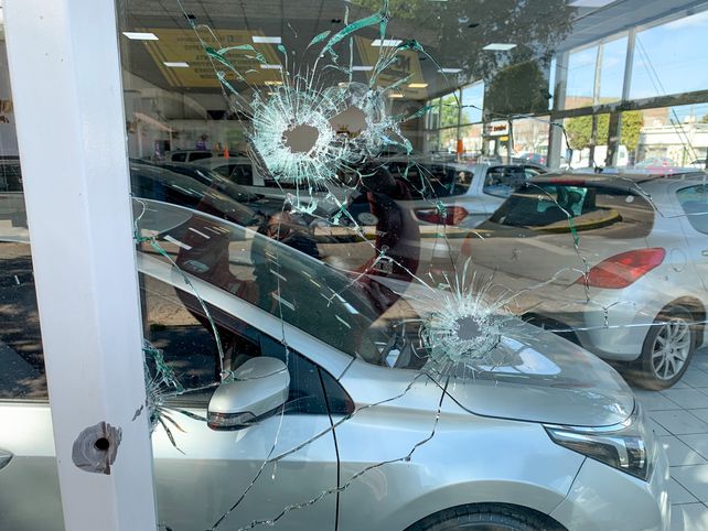 Una agencia de autos blanco de una balacera extorsiva