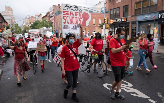 Padres y personal escolar marchan en protesta de la reapertura escolar en Nueva York.