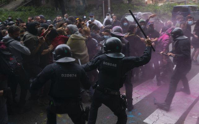 Agentes de policía de Riot usan sus bastones para dispersar a los manifestantes que intentan detener el desalojo de Axel Altadill