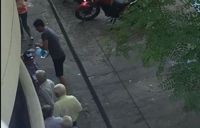 Pablo sirviendo agua en la fila del banco.&nbsp;