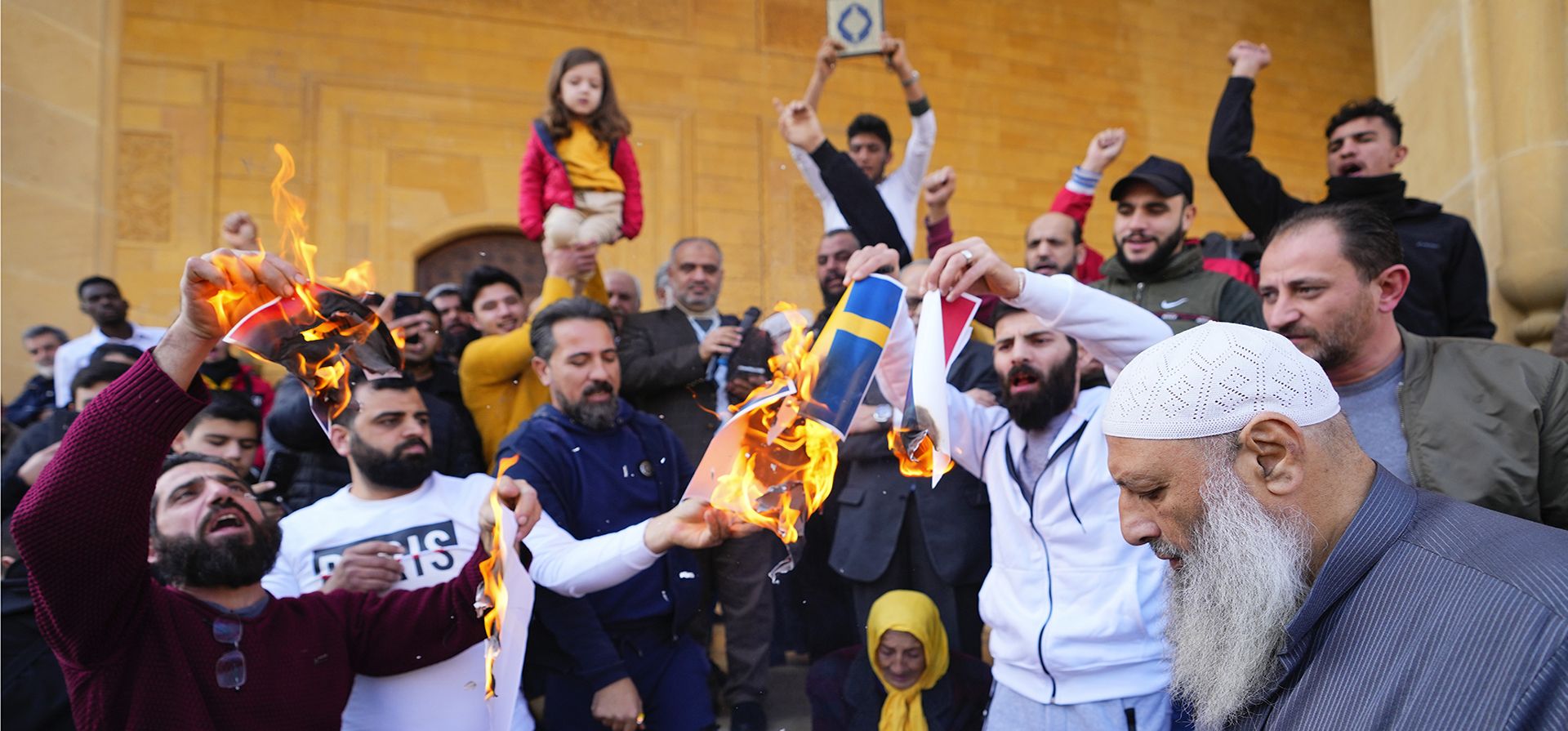 Decenas de manifestantes enojados queman banderas suecas y holandesas después de las oraciones del viernes frente a la mezquita Mohammad al-Amin para denunciar la reciente profanación del libro sagrado del Islam por parte de activistas de extrema derecha en países europeos en el centro de Beirut, Líbano, el viernes 27 de enero de 2023. (Foto AP/Hassan Ammar)