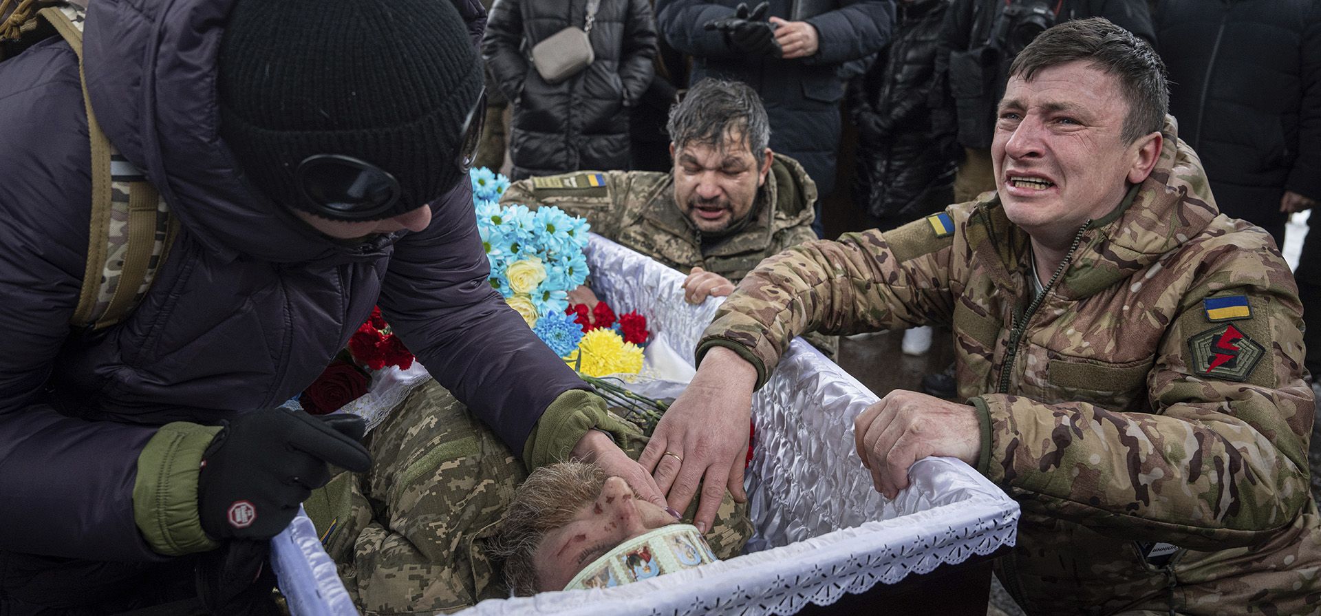 Militares ucranianos lloran cerca del ataúd de su camarada Andrii Trachuk durante su funeral en la Plaza de la Independencia en Kiev, Ucrania.  (Foto AP/Evgeniy Maloletka)