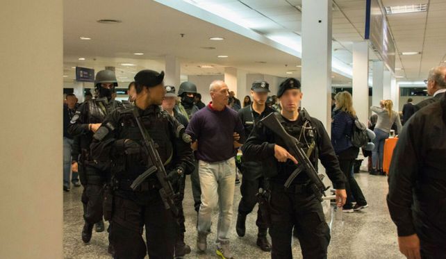 Arribo. Juliá camina custodiado al llegar a Ezeiza