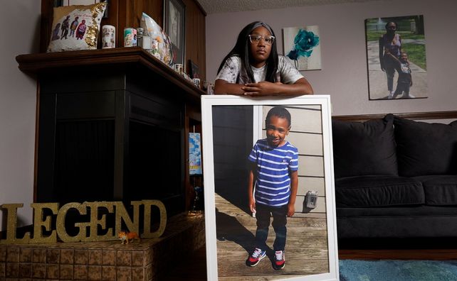 Charron Powell parada junto a la foto de su hijo