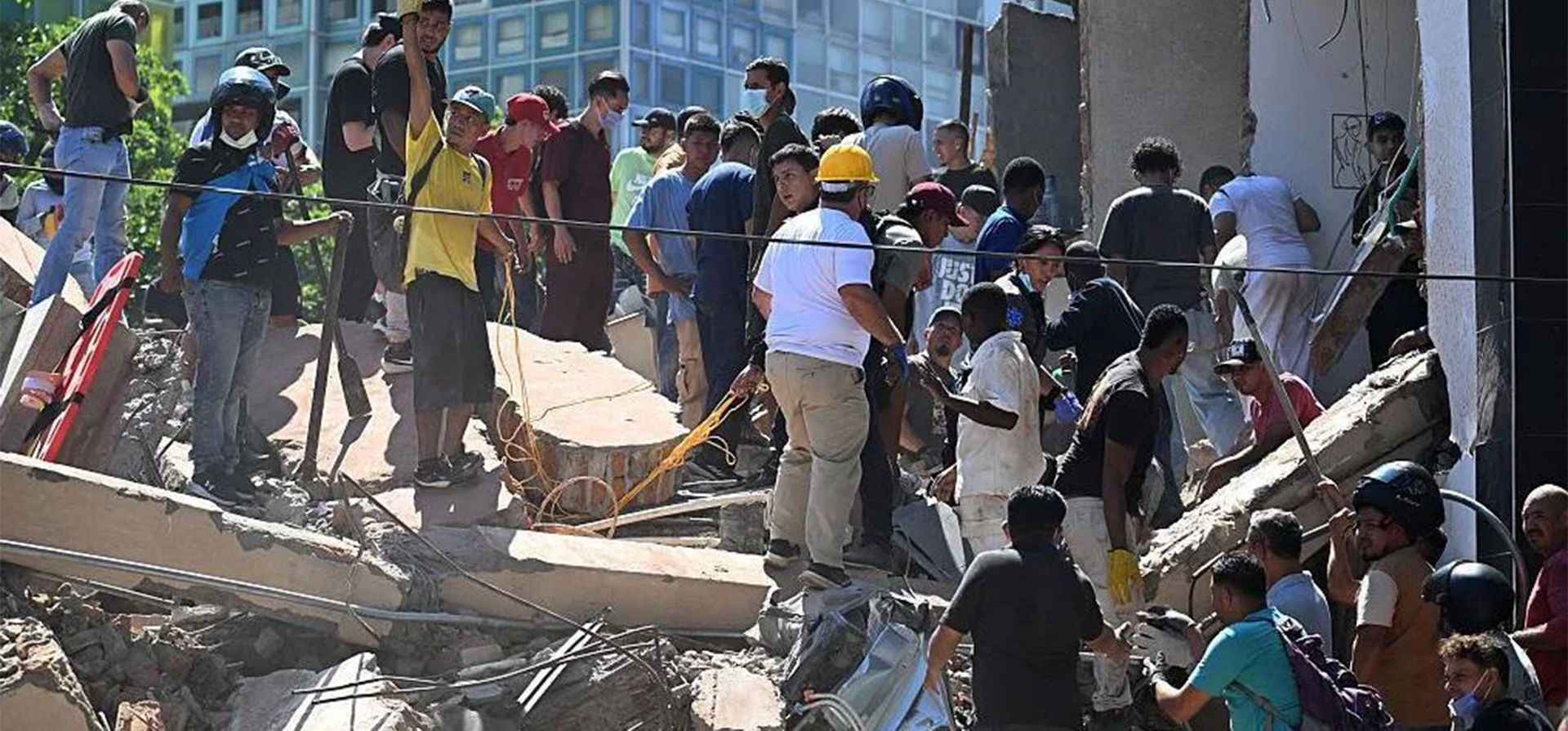 Personas buscan sobrevivientes entre los escombros de un edificio derrumbado en Cali. [Getty Images]