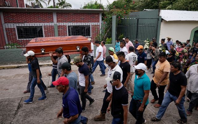 Familiares de una de las víctimas transportan el féretro hacia la iglesia del pueblo.
