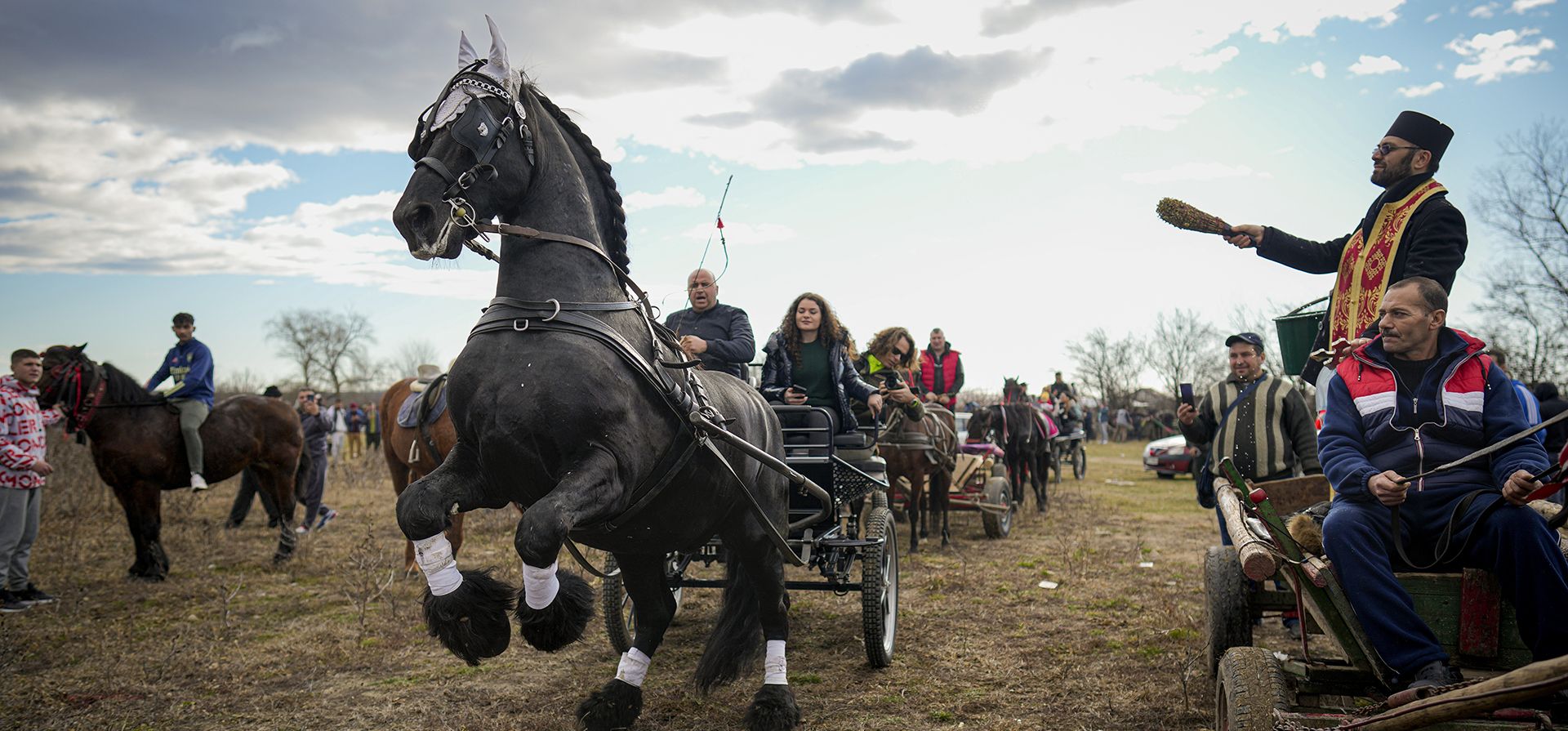 Un sacerdote bendice a los caballos y a sus dueños durante las celebraciones de la Epifanía en el pueblo de Pietrosani, Rumania, el viernes 6 de enero de 2023. (Foto AP/Vadim Ghirda)