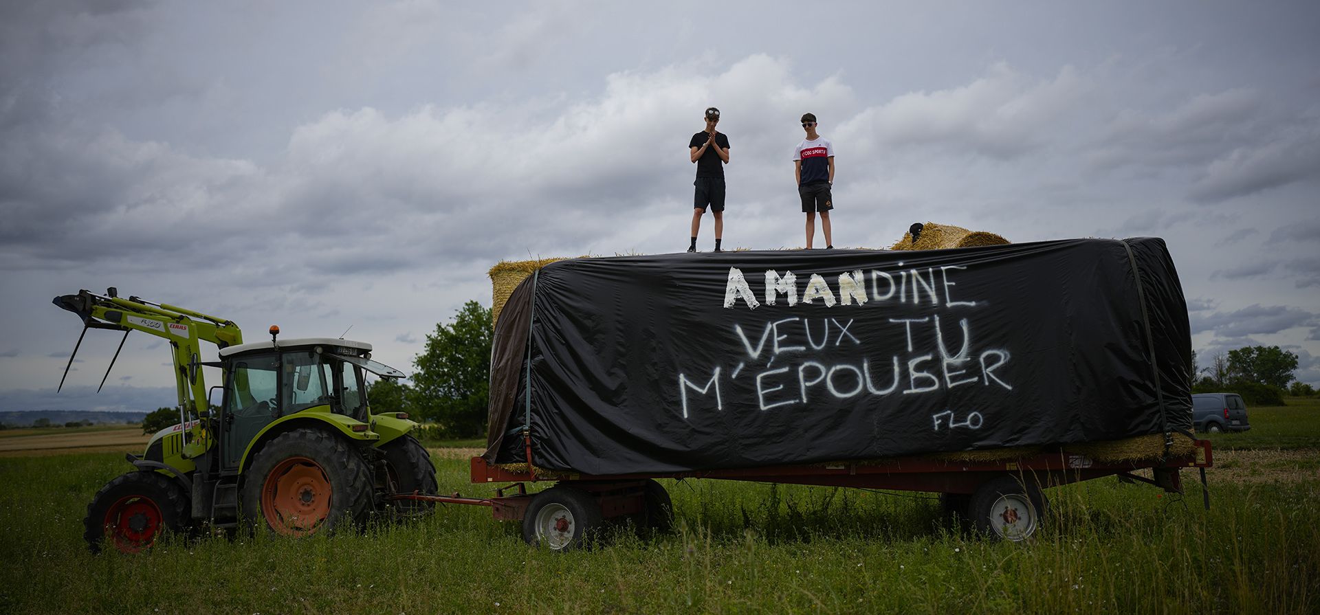 Dos espectadores del Tour de Francia se paran en una plataforma con una propuesta de matrimonio que dice "Amandine ¿Quieres casarte conmigo", firmado "Flo" durante la undécima etapa de la carrera ciclista de más de 180 kilómetros con inicio en Clermont-Ferrand y finaliza en Moulins, Francia, el miércoles 12 de julio de 2023. (Foto AP/Daniel Cole) Dos espectadores del Tour de Francia se paran en una plataforma con una propuesta de matrimonio que dice "Amandine ¿Quieres casarte conmigo", firmado "Flo" durante la undécima etapa de la carrera ciclista de más de 180 kilómetros con inicio en Clermont-Ferrand y finaliza en Moulins, Francia, el miércoles 12 de julio de 2023. (Foto AP/Daniel Cole)