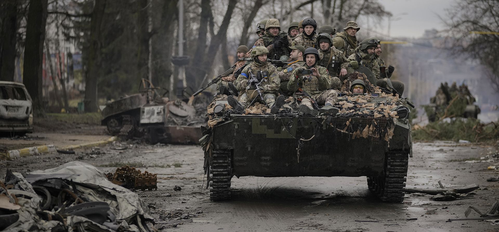 Soldados ucranianos transitan un camino entre objetivos rusos destruidos en Bucha, en las afueras de Kyiv, Ucrania, el domingo 3 de abril de 2022. (Foto AP)