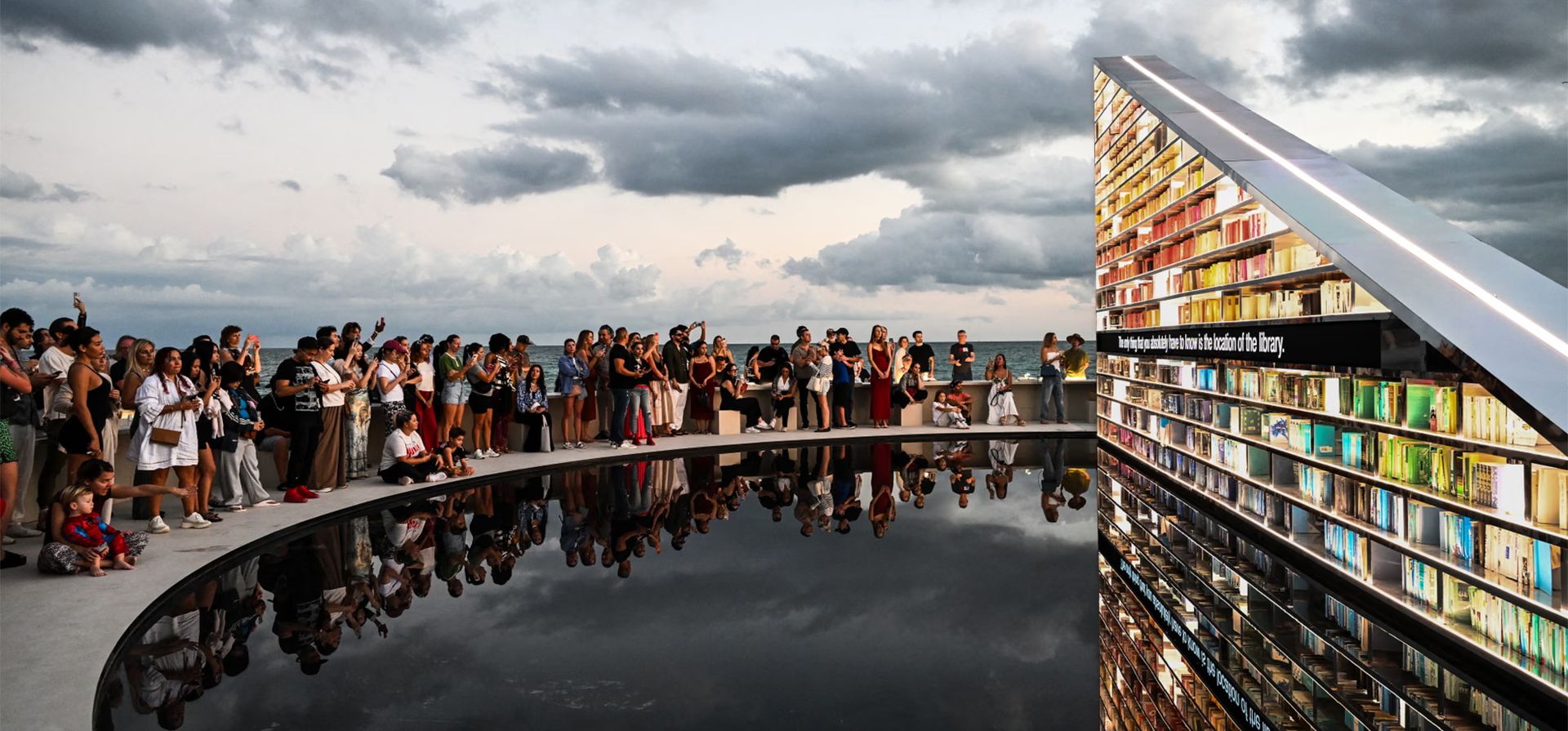 La gente contempla una instalación del artista británico Es Devlin. Library of Us es una estantería triangular giratoria de 15 metros de longitud (50 pies) que contiene 2.500 libros que han marcado la vida del artista. Está expuesto en Art Basel Miami Beach, Miami, EE. UU.. Fotografía: Chandan Khanna/AFP/Getty Images La gente contempla una instalación del artista británico Es Devlin. Library of Us es una estantería triangular giratoria de 15 metros de longitud (50 pies) que contiene 2.500 libros que han marcado la vida del artista. Está expuesto en Art Basel Miami Beach, Miami, EE. UU.. Fotografía: Chandan Khanna/AFP/Getty Images