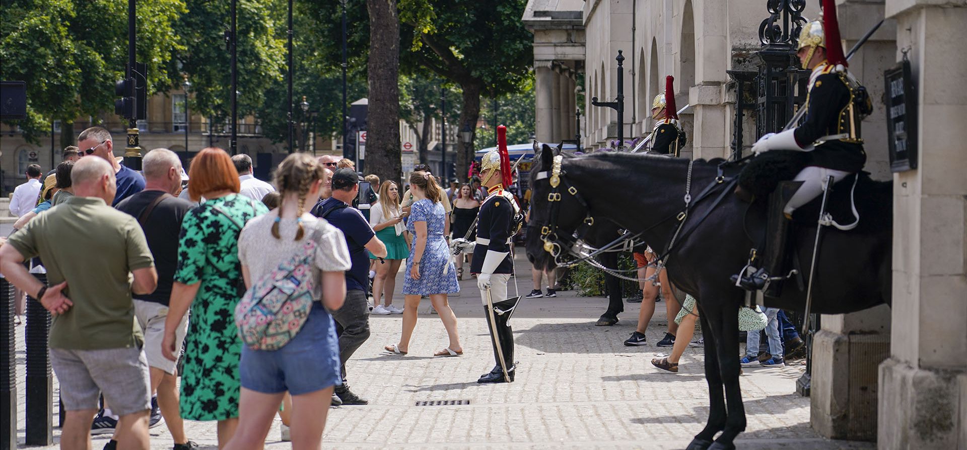 Miembros de la Caballería se encuentran afuera del Museo de la Caballería Doméstica mientras la gente pasa caminando y toma fotos, en Londres, el miércoles 13 de julio de 2022.
