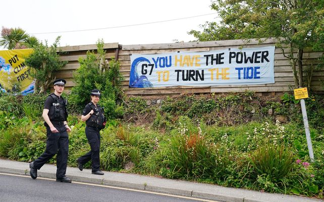 Agentes de policía pasan junto a una pancarta en Carbis Bay. Fotografía: Aaron Chown / PA