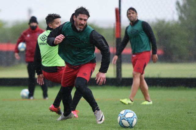 Pablo Pérez, durante un ensayo con pelota de ayer, mientras observa de fondo Kudelka. El once ideal habrá que ver si estará ante Talleres en Córdoba.