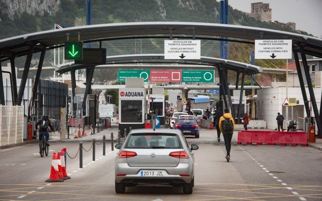 Una fila de autos esperan en la frontera entre España y Gibraltar. España ha levantado las restricciones de acceso a Gibraltar desde este martes.