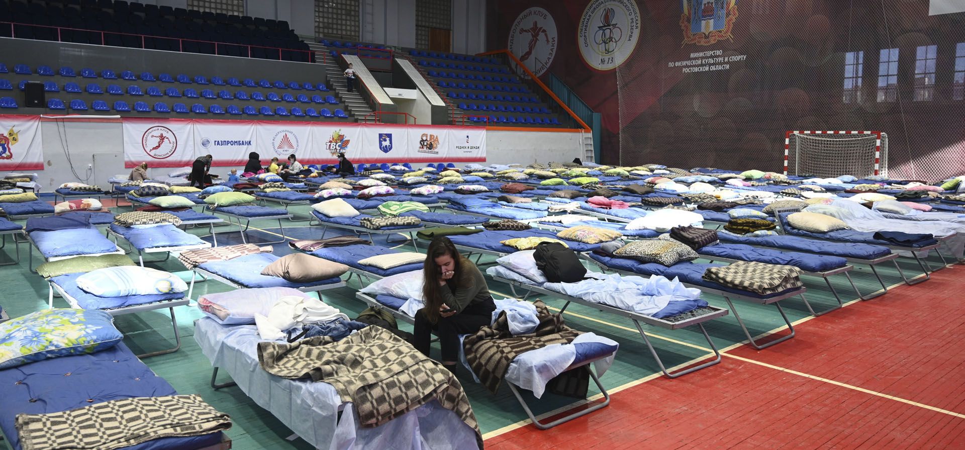 Civiles desplazados de las regiones de Donetsk y Lugansk, territorio controlado por los gobiernos separatistas prorrusos en el este de Ucrania, descansan en un pabellón deportivo en Taganrog, Rusia, el lunes 21 de febrero de 2022. Líderes mundiales están haciendo otro esfuerzo diplomático con la esperanza de prevenir una invasión rusa de Ucrania.