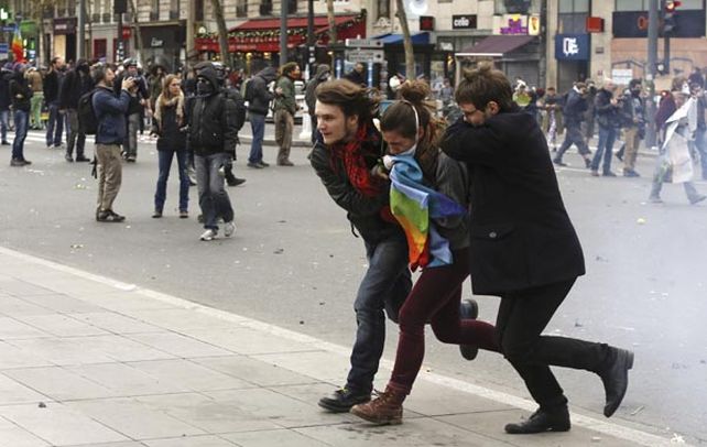 violencia. Militantes ecologistas huyen de los gases lacrimógenos policiales durante la protesta de ayer en París. (NA)