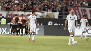 Gonzalo Maroni camina con la vista en el piso. El local, en el fondo, celebra su gol. Otro tanto que recibe Newells por una equivocación.