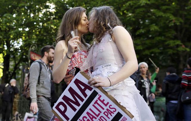 Parejas homosexuales festejan con champán en las calles de París.