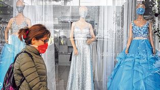 Nuevos tiempos. Una mujer cruza por delante de una vidriera de alta costura en pleno centro.