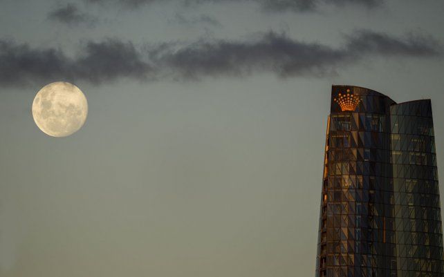 La luna se eleva sobre la Torre Barangaroo en Sydney. El miércoles 26 de mayo tendrá lugar un eclipse lunar total, también conocido como Super Luna de Sangre, en el que la luna aparece ligeramente rojiza y de color naranja.
