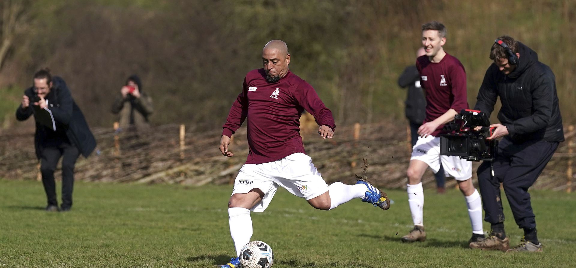 El futbolista brasileño Roberto Carlos anota un penal para Bull In The Barne United, durante un partido en el Hanwood Village Hall Recreation Centre, en Shrewsbury, Inglaterra, el viernes 4 de marzo de 2022, luego de que el equipo ganara en un sorteo el premio para que jugara una leyenda del fútbol. en su equipo.