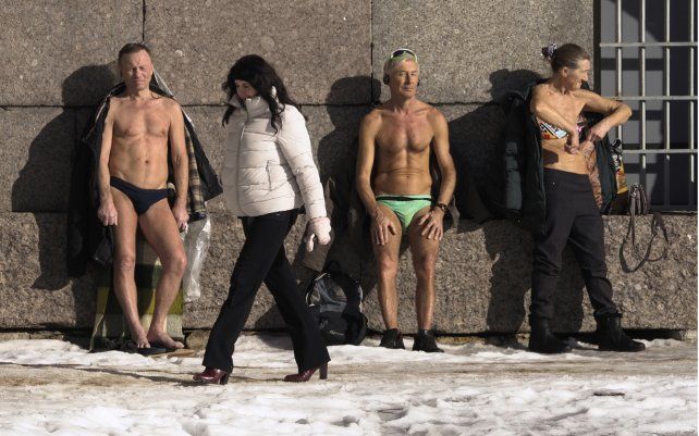 Un grupo de personas toma sol contra el muro de la fortaleza de Pedro y Pablo en la orilla del río Neva en San Petersburgo, Rusia.