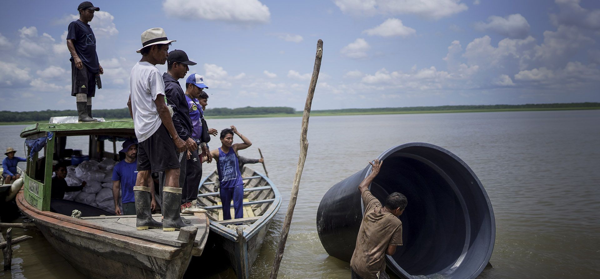 Un hombre de la comunidad indígena Tikuna lleva una cisterna de una organización sin fines de lucro que se puede usar para captar y almacenar agua de lluvia para la comunidad en medio de una sequía en Loma Linda, cerca de Leticia, Colombia, el domingo 20 de octubre de 2024. (Foto AP/Ivan Valencia)