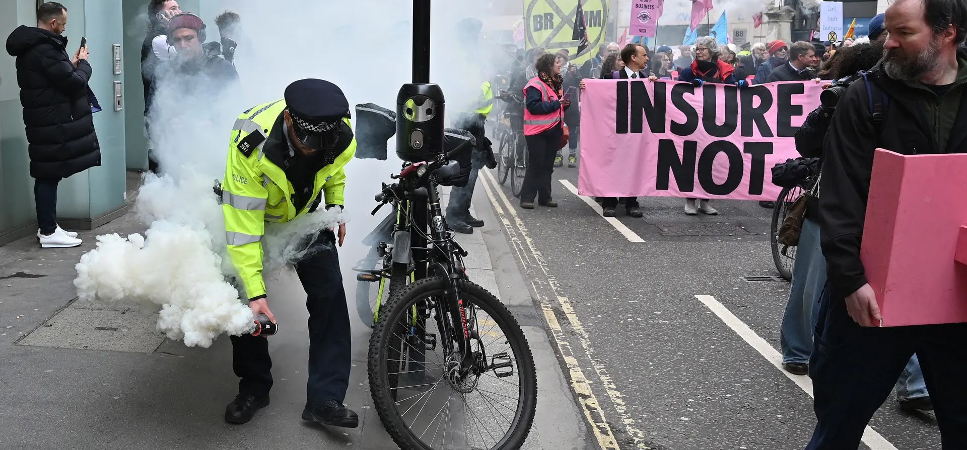 Un policía porta una bombona de humo confiscada a un activista durante una marcha de protesta convocada por Extinction Rebellion, Londres, Reino Unido. Fotografía: Justin Tallis/AFP/Getty Images Un policía porta una bombona de humo confiscada a un activista durante una marcha de protesta convocada por Extinction Rebellion, Londres, Reino Unido. Fotografía: Justin Tallis/AFP/Getty Images