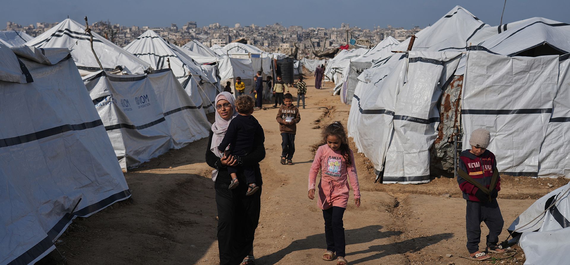 Una mujer palestina lleva a un niño mientras caminan entre tiendas de campaña instaladas para personas desplazadas en la ciudad de Gaza, el miércoles 17 de diciembre de 2025. (Foto AP/Jehad Alshrafi) Una mujer palestina lleva a un niño mientras caminan entre tiendas de campaña instaladas para personas desplazadas en la ciudad de Gaza, el miércoles 17 de diciembre de 2025. (Foto AP/Jehad Alshrafi)