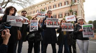 El diputado italiano Riccardo Magi (centro) muestra una pancarta exigiendo que no se permita la presencia de agentes del Servicio de Inmigración y Control de Aduanas (ICE) en los Juegos Olímpicos de Milán-Cortina durante una protesta organizada por el partido de centroizquierda +Europa frente a la embajada de Estados Unidos (al fondo), en Roma, el jueves 29 de enero de 2026. (Foto AP/Andrew Medichini)