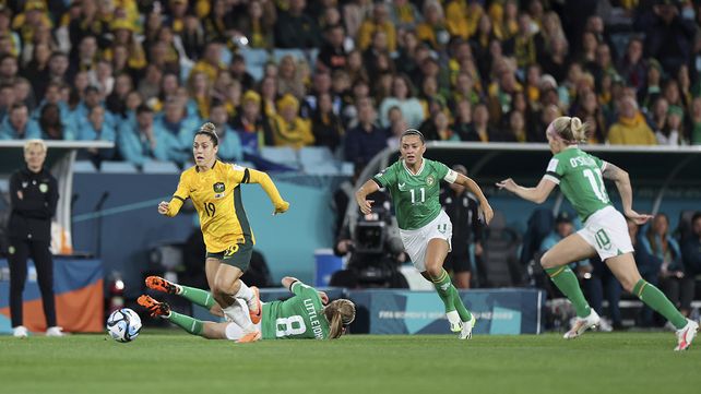 Katrina Gorry de Australia, a la izquierda, persigue el balón más allá de una Ruesha Littlejohn caída de Irlanda durante el partido de fútbol de la Copa Mundial Femenina entre Australia e Irlanda en el Estadio Australia en Sídney, Australia, el jueves 20 de julio de 2023. (Foto AP/Sophie Ralph)