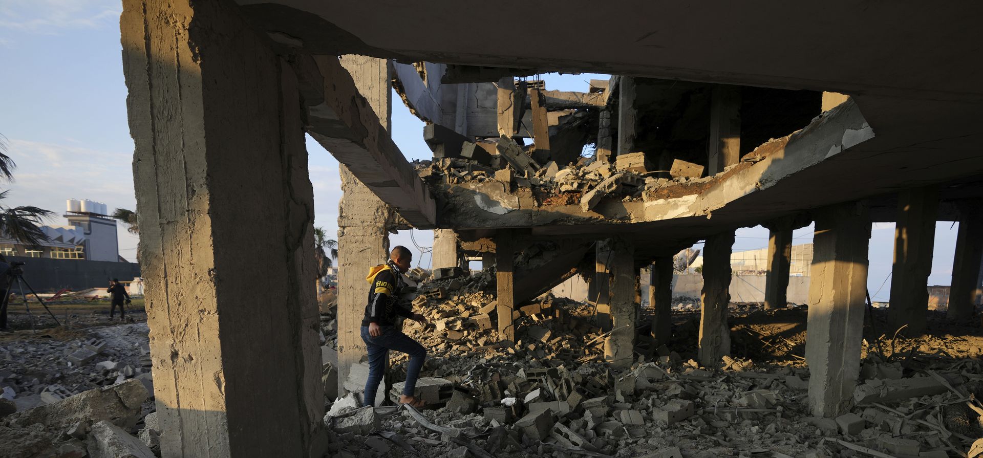 La gente pasa por los escombros de un edificio destruido por los ataques aéreos israelíes en la ciudad de Gaza, el lunes 13 de febrero de 2023. Más temprano el lunes, el ejército israelí dijo que aviones bombardearon un sitio de fabricación de cohetes de Hamas e instalaciones militares en la Franja de Gaza después de que militantes palestinos lanzaran cuatro cohetes hacia el sur de Israel durante la noche. (Foto AP/Adel Hana)