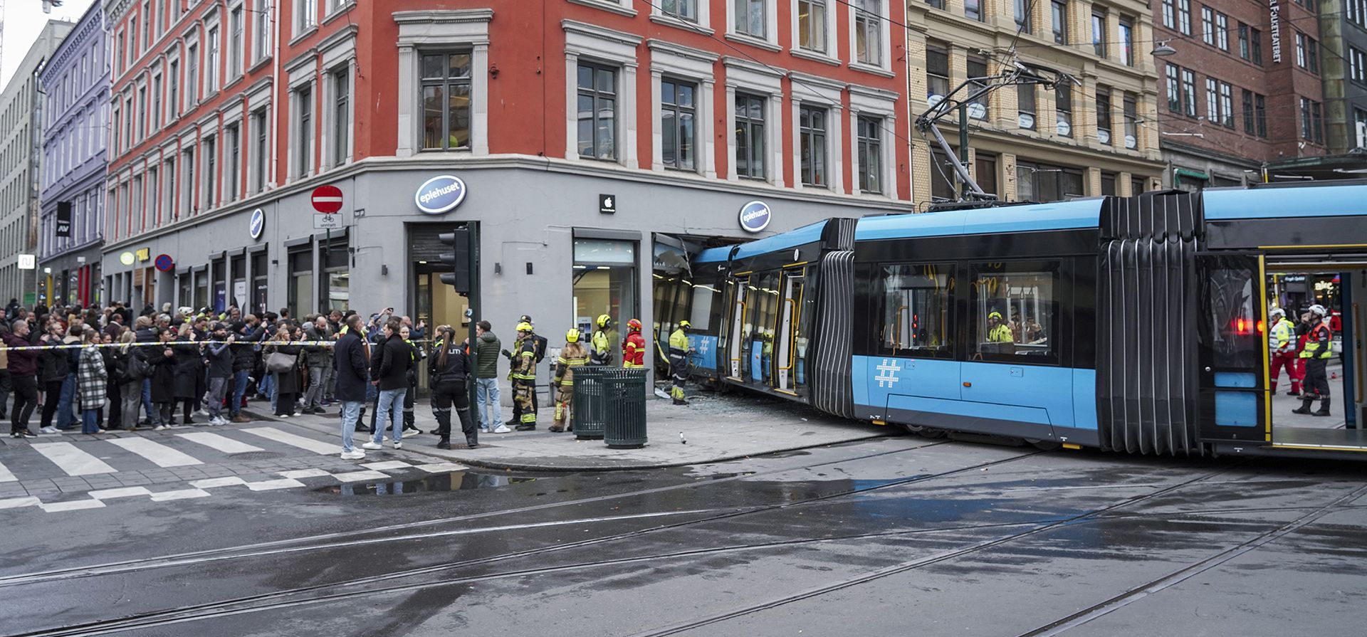 Personas y rescatistas se reúnen en el lugar donde un tranvía descarriló y se estrelló contra un edificio en el centro de Oslo, Noruega, el martes 29 de octubre de 2024. (Terje Pedersen/NTB Scanpix vía AP)