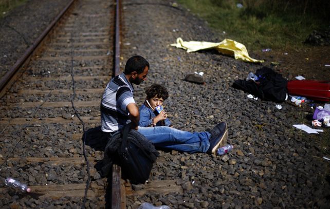 Un migrante y su hijo toman un descanso en el sur de Hungría.