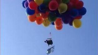 Detenido por sobrevolar una ciudad atado a cien globos con helio