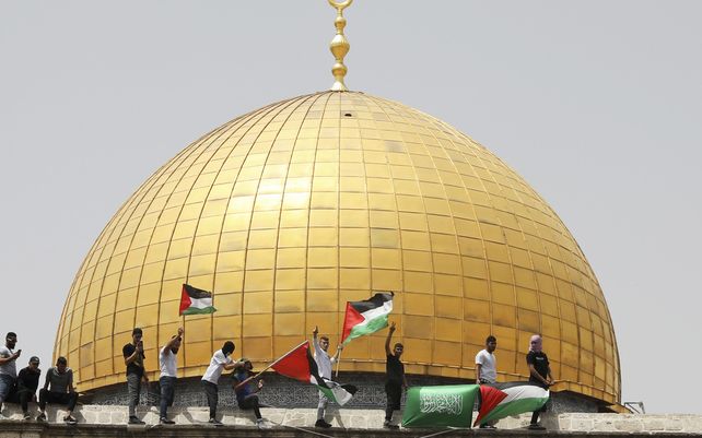 Palestinos ondean banderas nacionales y de Hamas frente al santuario de la Cúpula de la Roca en el complejo de la mezquita al-Aqsa en Jerusalén. EE.UU y la comunidad internacional planean comprometerse con los palestinos para reactivar los esfuerzos de paz.