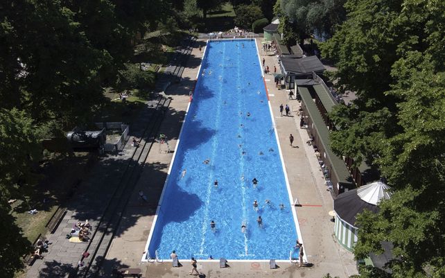 Nadadores disfrutan de la piscina en un día cálido en Jesús Green Lido en Cambridge