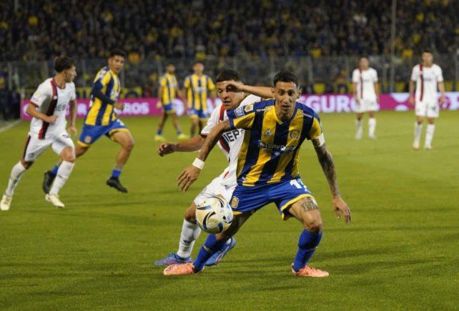 Ángel Di María intenta escapar a su marcador de San Lorenzo.