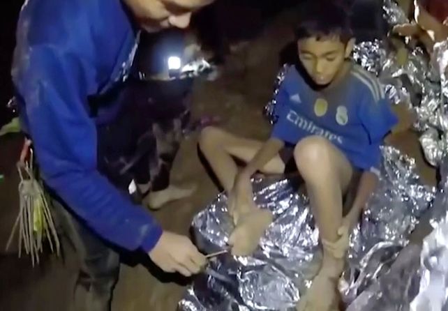 Socorrista. Uno de los niños es examinado por un médico militar tailandés.