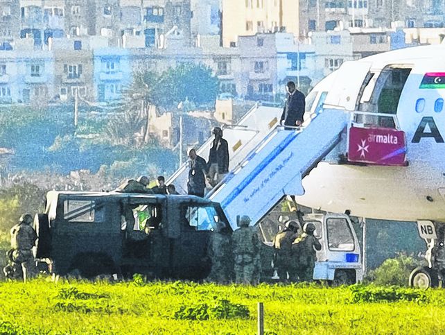 Alarma. Fuerzas de seguridad ayudan a descender a la tripulación del Airbus de la aerolínea libia.
