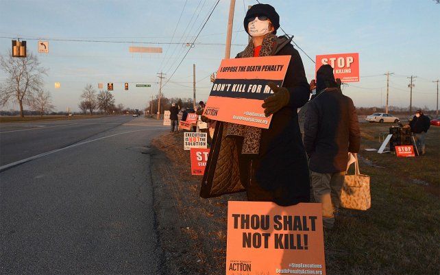 Una manifestante sostiene un cartel frente al Complejo Correccional Federal en Terre Haute, Indiana, para protestar por la ejecución programada de Lisa Montgomery.