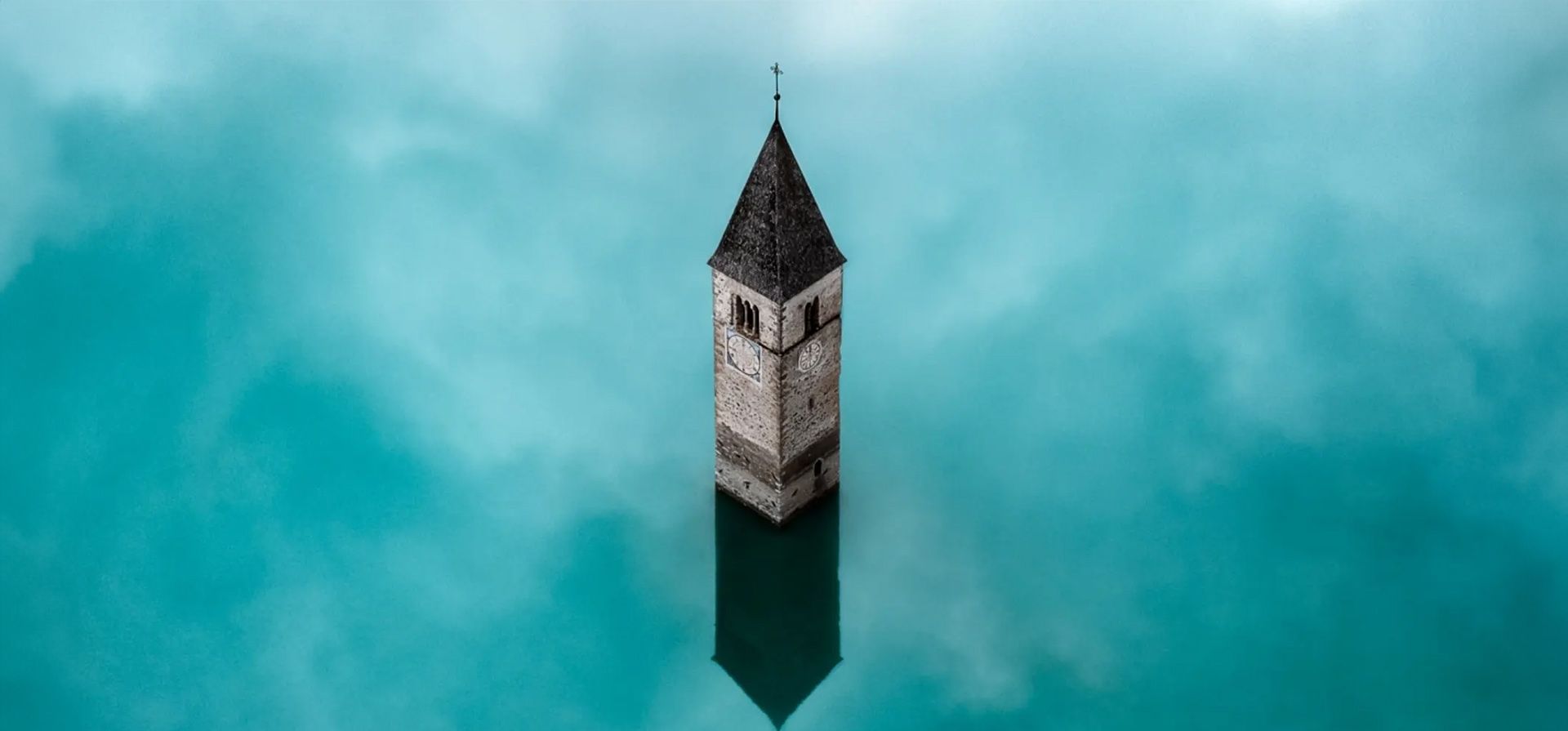 Torre de la iglesia hundida por Pawe Jagieo. Una torre de la iglesia del siglo 14 en Italia se erige como un recordatorio conmovedor del pueblo hundido de Curon Venosta. En 1950, todo el pueblo quedó sumergido tras la construcción de una presa, lo que dio lugar a la creación de la cuenca artificial conocida como lago Resia. Hoy en día, solo queda la torre de la iglesia.