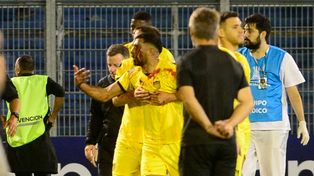 Maximiliano Olivera es contenido por sus compañeros tras la reacción que tuvo por el piedrazo.
