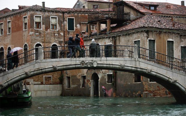 El mural de Banksy sobre un niño migrante, en la parte inferior central, parcialmente sumergido. La ciudad italiana de Venecia a solo tres días después de que experimentó su peor inundación en 50 años, noviembre de 2019.