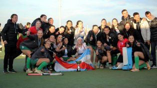 Jugadoras y cuerpo técnico de la Federación Entrerriana de Hockey celebran con el trofeo.