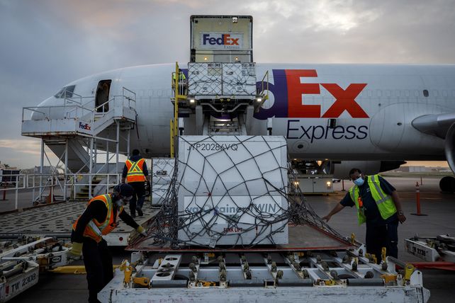 Trabajadores aeronáuticos descargan un envío de la vacuna Moderna COVID-19 en el centro de FedEx en el Aeropuerto Internacional Pearson en Toronto